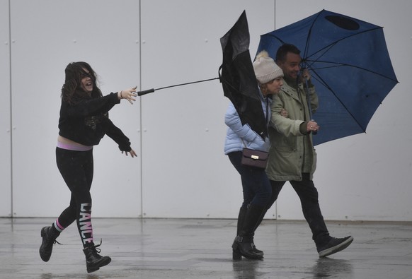 epa08220047 People struggle with umbrellas as they walk in Bournemouth, Britain, 15 February 2020. Storm Dennis is bringing heavy rain and strong winds across the UK. EPA/NEIL HALL