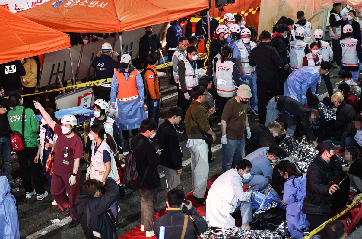 epa10273601 Injured people are being attended to on a street in Seoul's Itaewon district, after about 50 people fell into cardiac arrest from a stampede during Halloween celebrations in Seoul, So ...