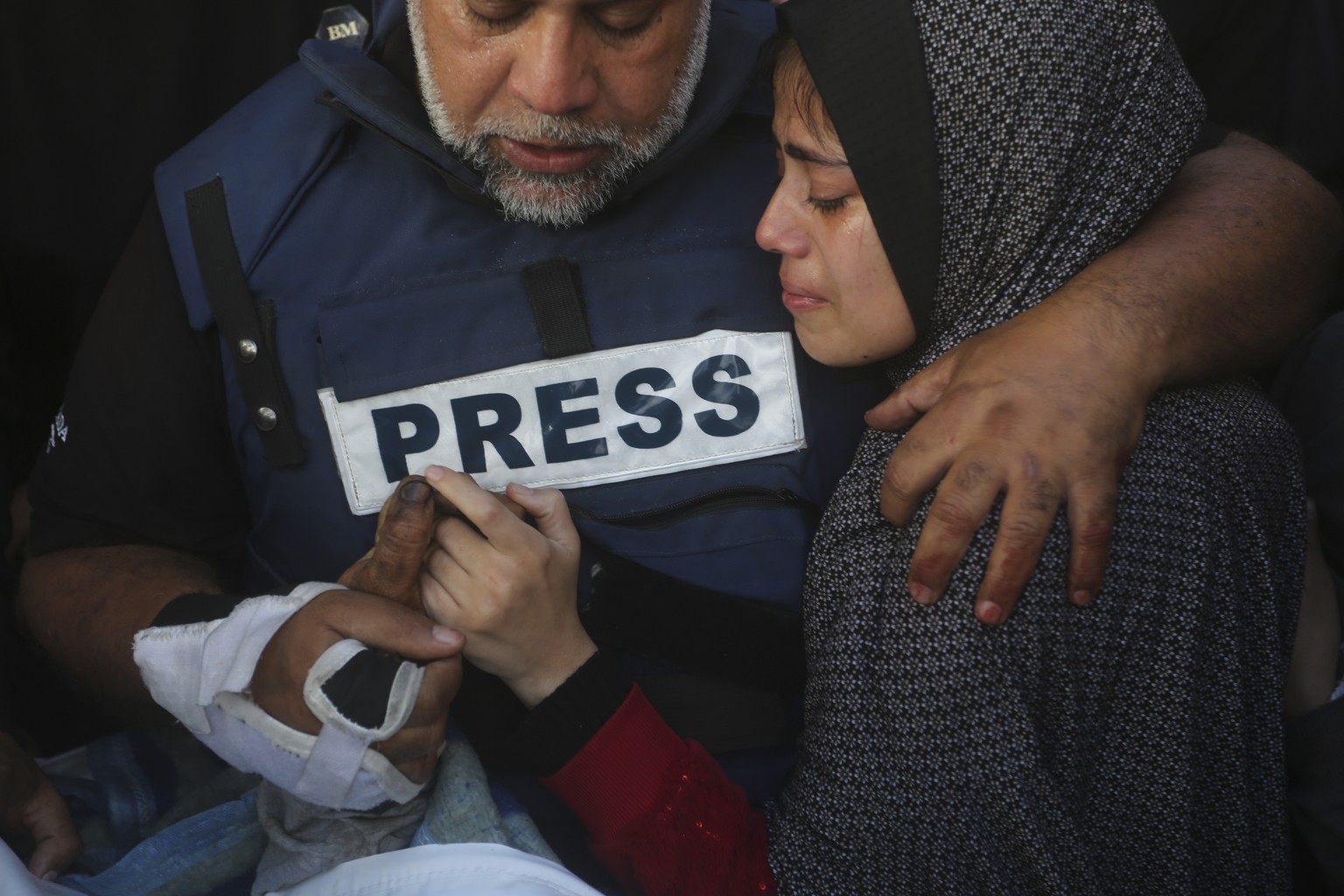 Al Jazeera journalist Wael Dahdouh holds the hand of his son Hamza, who also worked for Al Jazeera and who was killed in an Israeli airstrike in Rafah, Gaza Strip, Sunday, Jan. 7, 2024. Dahdouh lost h ...