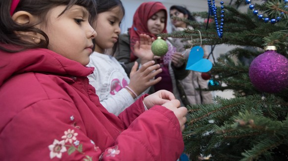 epa05677112 Refugee children decorate a Christmas tree at a preliminary reception centre in Berlin, Germany, 15 December 2016. The decorating was part of the presentation of the first &#039;Game and c ...