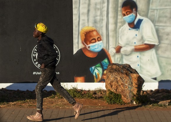 A young boy walks past a mural promoting vaccination for COVID-19 in Duduza township, east of Johannesburg, South Africa, Wednesday, June 23, 2021. (AP Photo/Themba Hadebe)