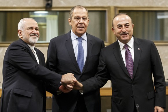 epa07238662 Iranian Foreign Minister Mohammad Javad Zarif, (L), Russian Foreign Minister Sergei Lavrov, (C), and Turkish Foreign Minister Mevlut Cavusoglu, (R), shakes hands after a joint statement fo ...