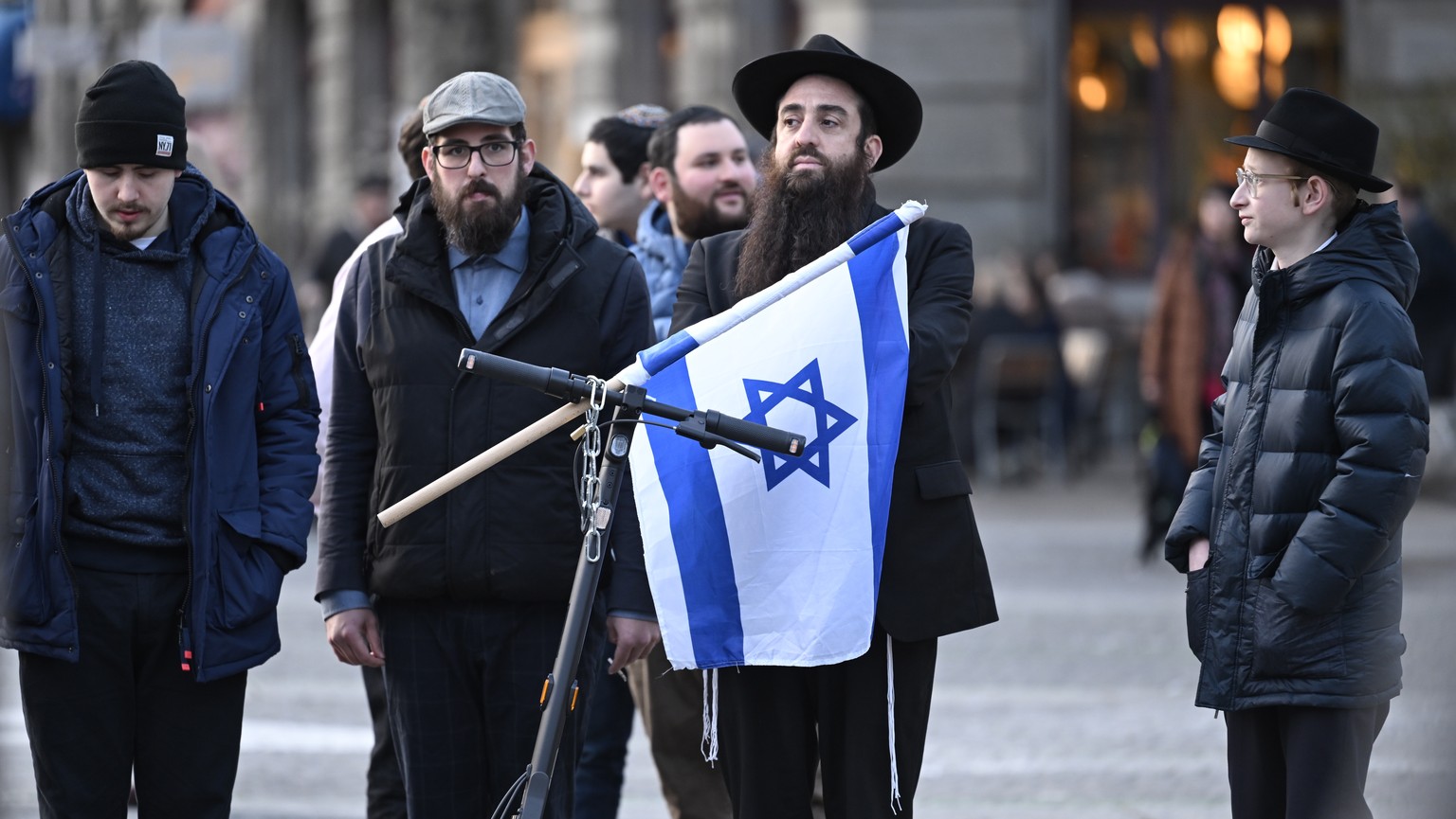 epa11197071 People gather in Helvetiaplatz during a rally against anti-Semitism, one day after a Jewish man was stabbed, in Zurich, Switzerland, 03 March 2024. People carried yellow umbrellas as a sym ...