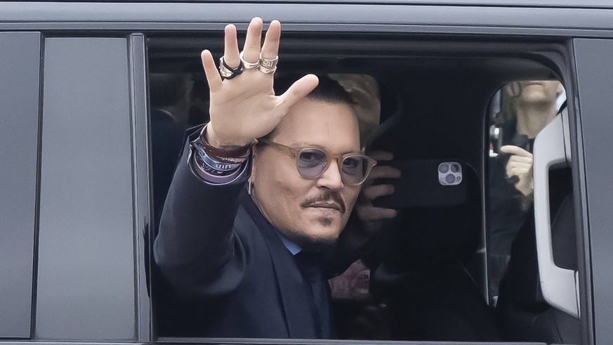 Johnny Depp waves to his fans as he arrives at the Fairfax County Courthouse, in Fairfax, for the resumption of his civil trial with Amber Heard, Friday, May 27, 2022. Depp brought a defamation lawsui ...