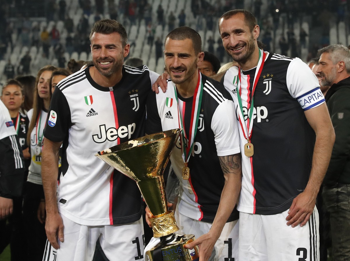 Juventus' Andrea Barzagli, Juventus' Leonardo Bonucci, and Juventus' Giorgio Chiellini, from left to right, pose after winning the Serie A soccer title trophy, at the Allianz Stadium, i ...