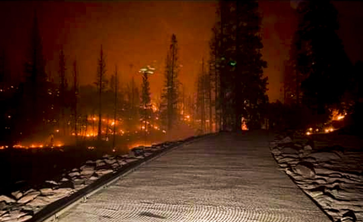 epa08651331 A handout photo made available by the California National Guard shows the Creek Fire burns along a road as dozens of evacuees had to be flown to safety by a Cal Guard CH-47 Chinook after b ...