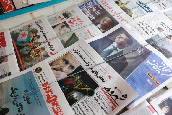 epa11766053 Iranian newspapers with pictures of former Syrian President Bashar al-Assad and reporting about al-Assad&#039;s fall are displayed at a kiosk in Tehran, Iran, 09 December 2024. The Iranian ...