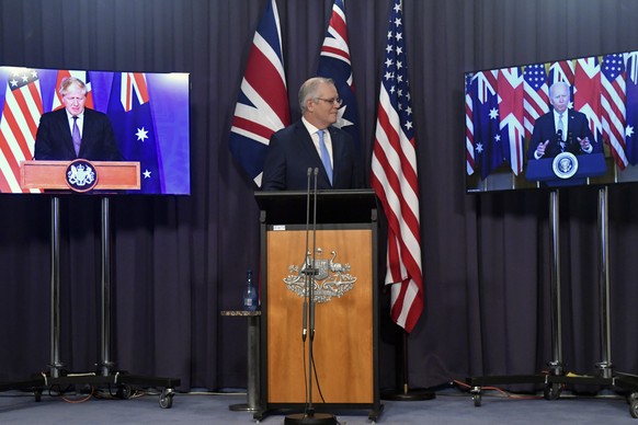 Australia&#039;s Prime Minister Scott Morrison, center, appears on stage with video links to Britain&#039;s Prime Minister Boris Johnson, left, and U.S. President Joe Biden at a joint press conference ...