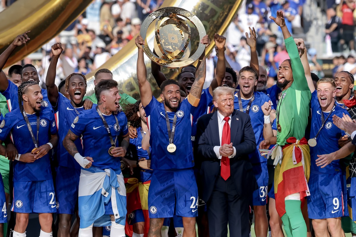 epa12236603 Chelsea FC players lift the trophy as US President Donald Trump (5-R) looks on after winning the FIFA Club World Cup 2025 final match between Chelsea FC and Paris Saint-Germain, in East Ru ...