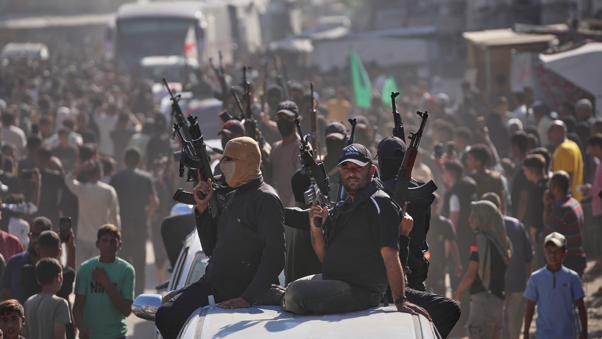 Hamas gunmen on pickup trucks escort buses carrying freed Palestinian prisoners as they are greeted following their release from Israeli jails under a cease-fire agreement between Hamas and Israel, in ...