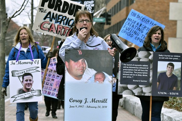 FILE - In this Friday, April 12, 2019 file photo, Cheryl Juaire, of Marlborough, Mass., center, leads a protest near the Arthur M. Sackler Museum at Harvard University, in Cambridge, Mass. Harvard Uni ...