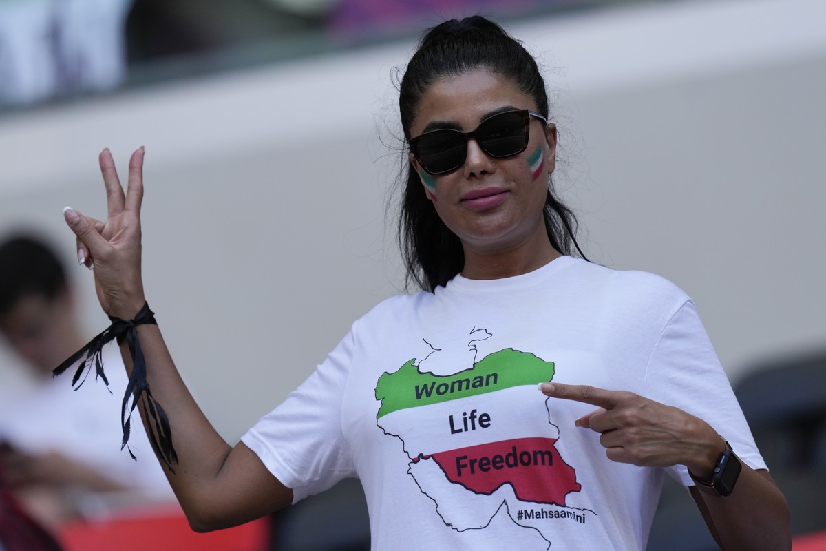 A soccer fan wears a black ribbon and a T-shit reading "Woman, Life, Freedom" in memory of Mahsa Amini, a woman who died while in police custody in Iran, prior to the World Cup group B socce ...