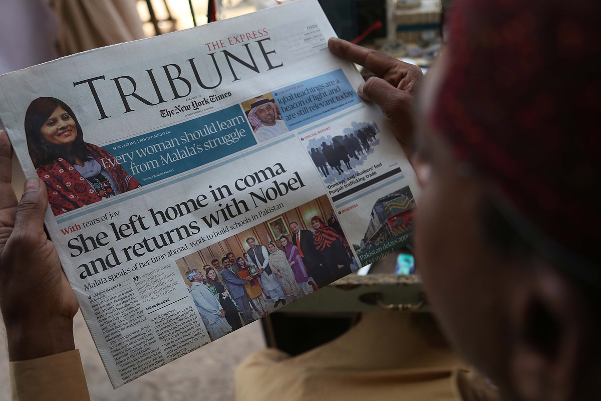 epa06637352 A man reads front page news of Pakistani girl Nobel Peace Laurette, Malala Yousafzai's return to the home country, in Karachi, Pakistan, 30 March 2018. Malala Yousafzai returned to Pa ...