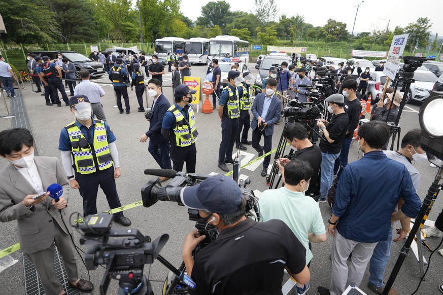 Members of media wait for Samsung Electronics Vice Chairman Lee Jae-yong as police officers stand guard outside of a detention center in Uiwang, South Korea, Friday, Aug. 13, 2021. Embattled Samsung l ...