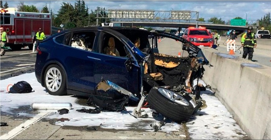 FILE - In this March 23, 2018, file photo provided by KTVU, emergency personnel work at the scene where a Tesla electric SUV crashed into a barrier on U.S. Highway 101 in Mountain View, Calif. Federal ...