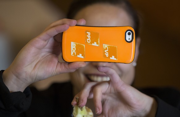 Logos der CVP kleben an einem Mobiltelefon einer CVP-Delegierten, an der CVP Delegiertenversammlung am Samstag, 22. November 2014 in Bern. (KEYSTONE/Peter Klaunzer)