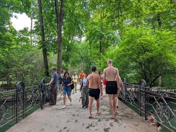 Young People Cooling Off In The Eisbach In Munich Young people return from swimming in the fast-flowing Eisbach stream in Munich, Germany, on July 6, 2025. Munich Germany PUBLICATIONxNOTxINxFRA Copyri ...