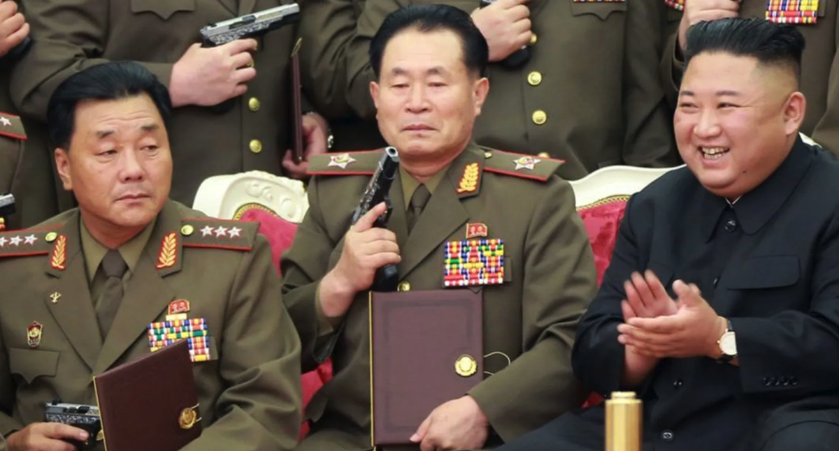 Kim Jong Un (à droite) et le général Kim Yong Bok (à gauche) lors d'une présentation de pistolets donnés en 2020.