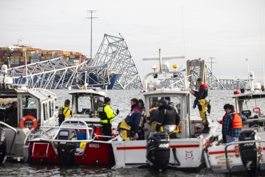 epa11244497 Rescue personnel gather on the shore of the Patapsco River after a container ship ran into the Francis Scott Key Bridge (back) causing its collapse in Baltimore, Maryland, USA, 26 March 20 ...