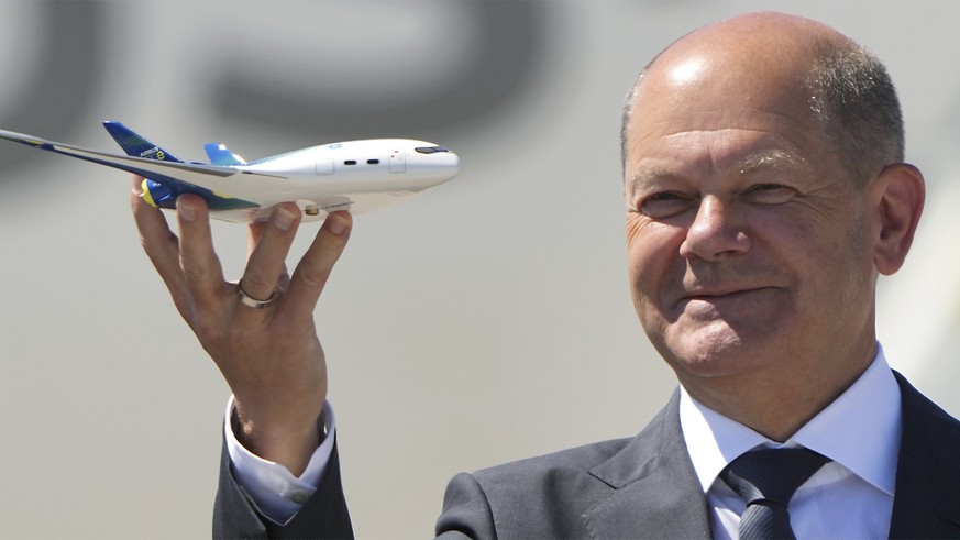 German Chancellor Olaf Scholz holds a model of an airplaine during his visit at the ILA Berlin Air Show in Schoenefeld near Berlin, Germany, Wednesday, June 22, 2022. The Berlin Air Show takes place f ...