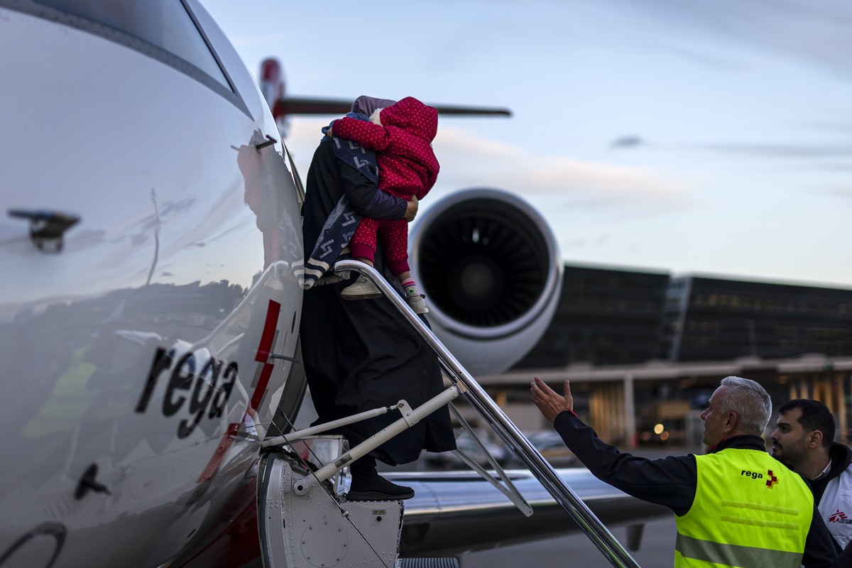 An injured child and his mother are taken to an ambulance after landing at Zurich Airport, Switzerland, on Friday, October 24, 2025. As part of a humanitarian operation, Switzerland has evacuated a fi ...