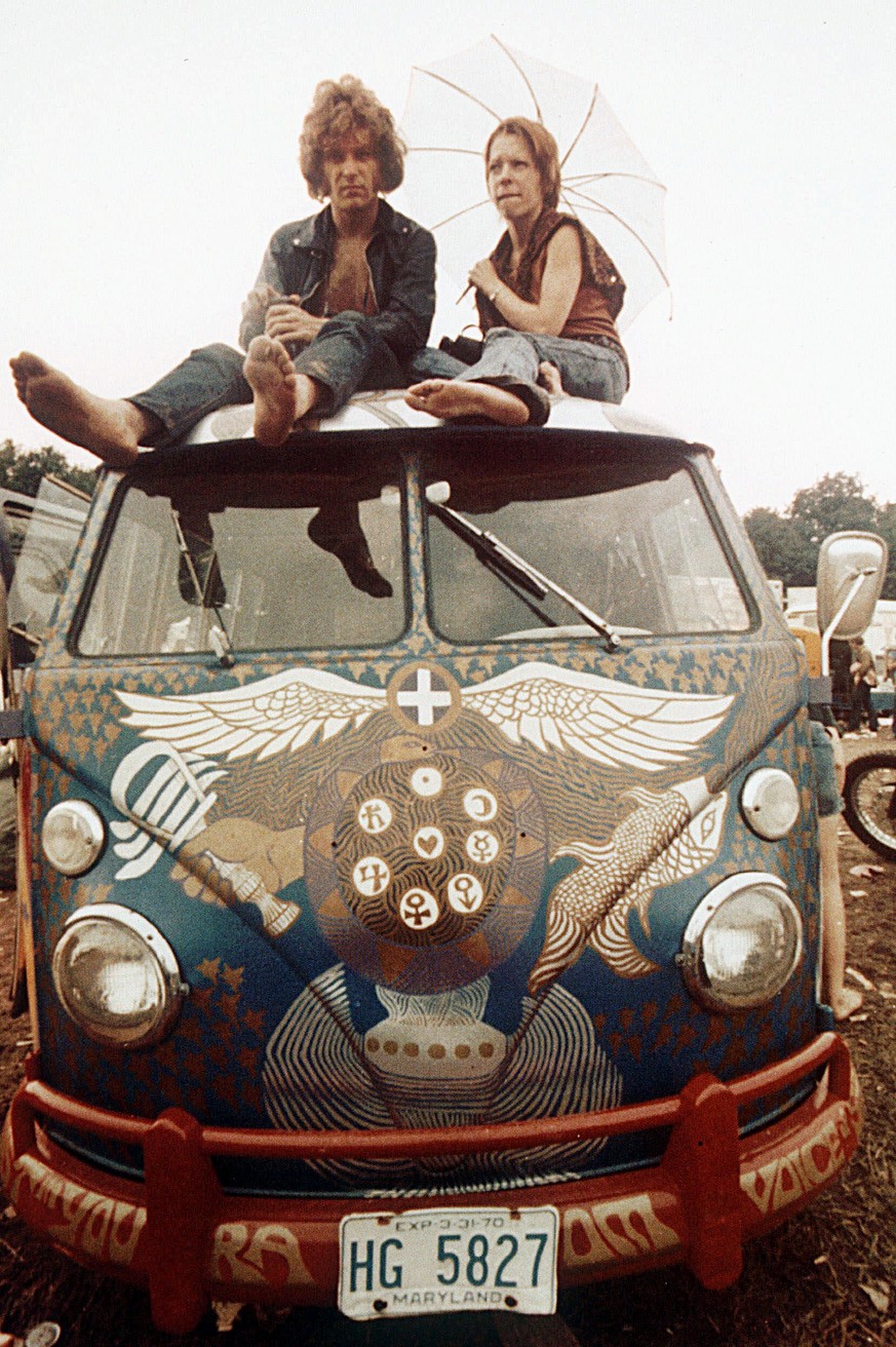 FILE - This 1969 file photo, concert-goers sit on the roof of a Volkswagen bus at the Woodstock Music and Arts Fair at Bethel, N.Y. The fashion of the period is included in a new book, The Looks of L ...