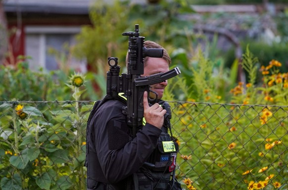 epa13134587 A police officer armed with a machine pistol stands at the scene of an operation in an allotment garden community in Berlin's Spandau district following a car-ramming attack near the  ...