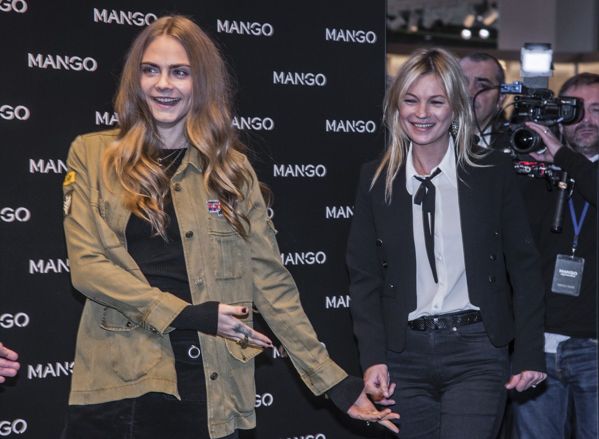 Models Cara Delevingne, left, and and Kate Moss pose for photographers as they arrive for the opening of the Mango fashion designer store, during Milan's fashion week, in Milan, Wednesday, Sept.  ...