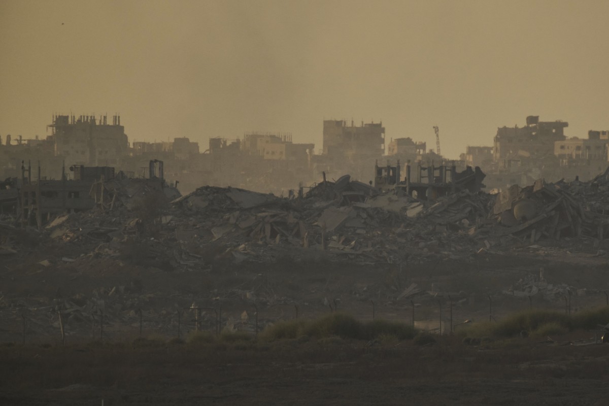 Buildings that were destroyed during the Israeli ground and air operations are engulfed by clouds of smoke in the northern Gaza Strip during the sunset, as seen from southern Israel, Monday, Sept. 15, ...
