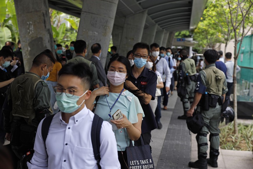 Riot police check IDs of workers near the Legislative Council building in Hong Kong, Wednesday, May 27, 2020. Hong Kong&#039;s legislature begins debate on a bill that would criminalize insulting or a ...