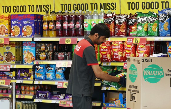 epa11548364 A supermarket staff loads shelves at a supermarket in London, Britain, 14 August 2024. UK Inflation has risen to 2.2 percent driven by an increase in energy costs, the Office for National  ...