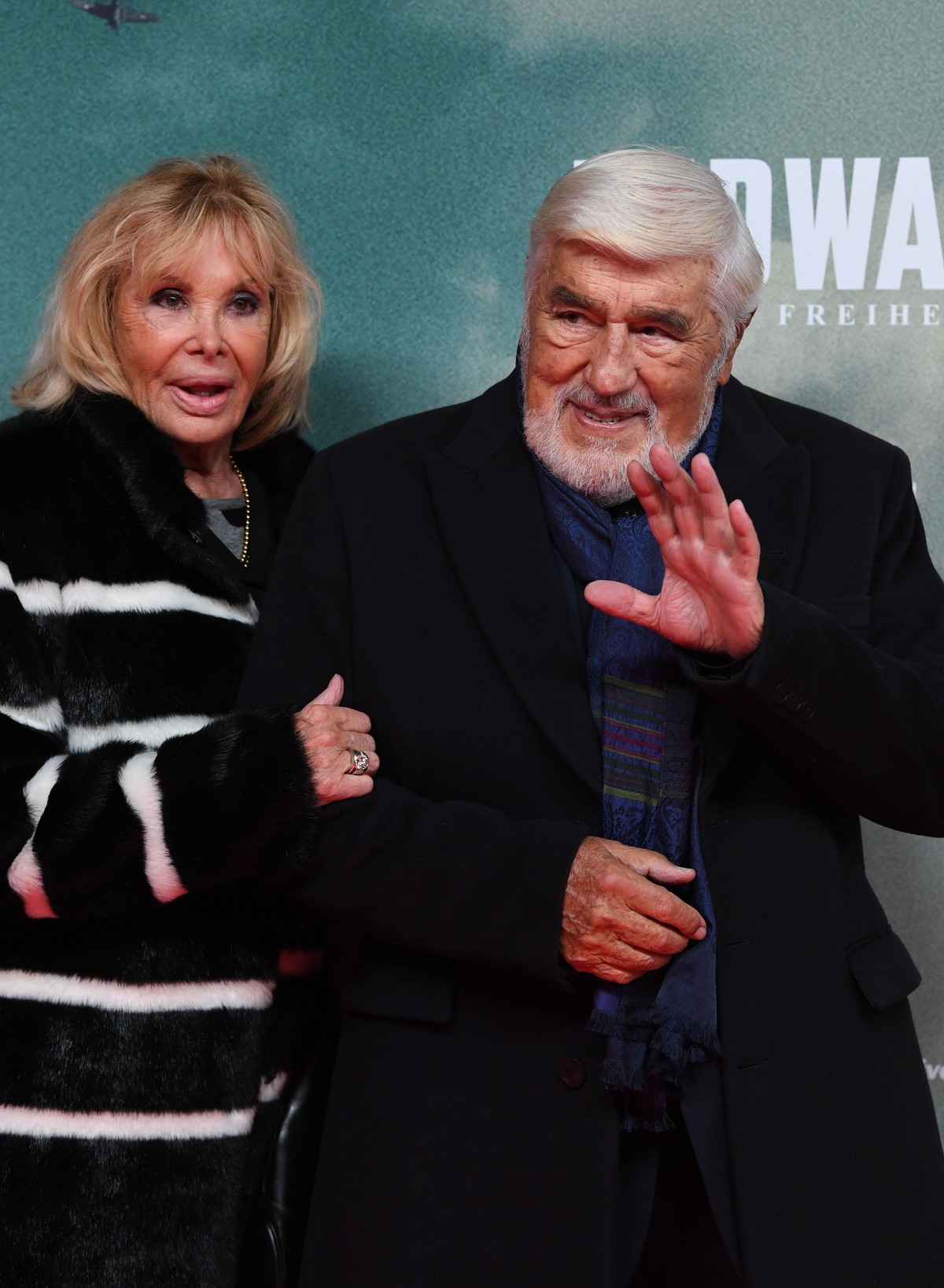 epa07947257 German actor Mario Adorf (R) and his wife Monique Faye arrive for the premiere of the film 'Midway' in Munich, Germany, 24 October 2019. The movie opens across German theaters on ...