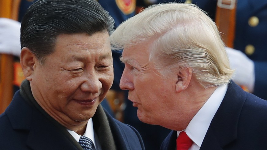 In this Nov. 9, 2017, photo, U.S. President Donald Trump, right, talks to Chinese President Xi Jinping during a welcome ceremony at the Great Hall of the People in Beijing. The brewing China-U.S. trad ...