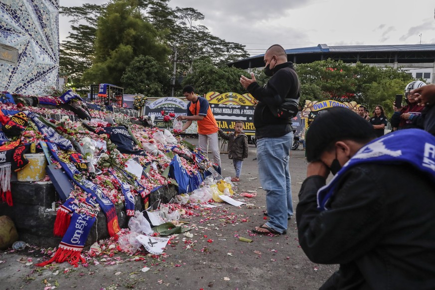 epa10221040 People gather as they pay condolence to the victims of the soccer match riot and stampede outside Kanjuruhan Stadium in Malang, East Java, 03 October 2022. According to Indonesia&#039;s Co ...