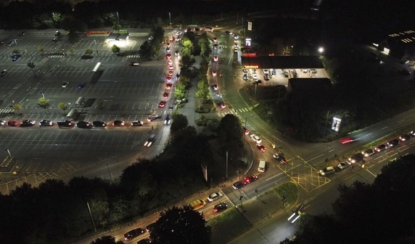 Motorists queue to fill their cars at a Sainsbury&#039;s fuel station in Ashford, England, Saturday, Sept. 25, 2021. The British government is expected to ease visa rules for truck drivers to help fix ...