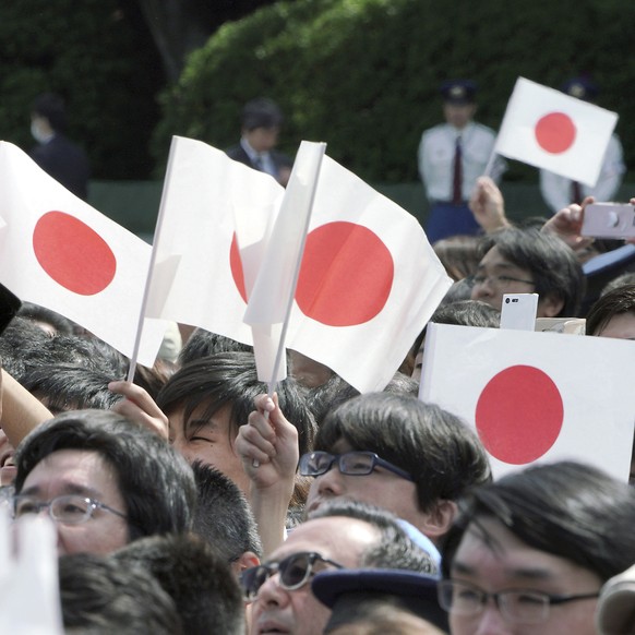 Visitors wave Japanese flags as they wait to see Japan&#039;s new Emperor Naruhito making his first public appearance with his imperial families at Imperial Palace Saturday, May 4, 2019, in Tokyo. (AP ...