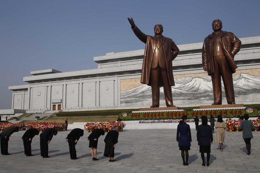 People bow in front of the bronze statues of late leaders Kim Il Sung and Kim Jong Il on the occasion of the 108th birth anniversary of Kim Il Sung in Pyongyang, North Korea Wednesday, April 15, 2020. ...