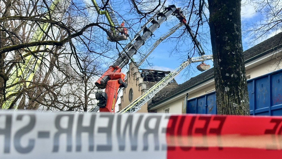Einsatzkräfte sichern die Brandruine am Zürcher Lindenhof und entfernen Teile des beschädigten Dachstocks.