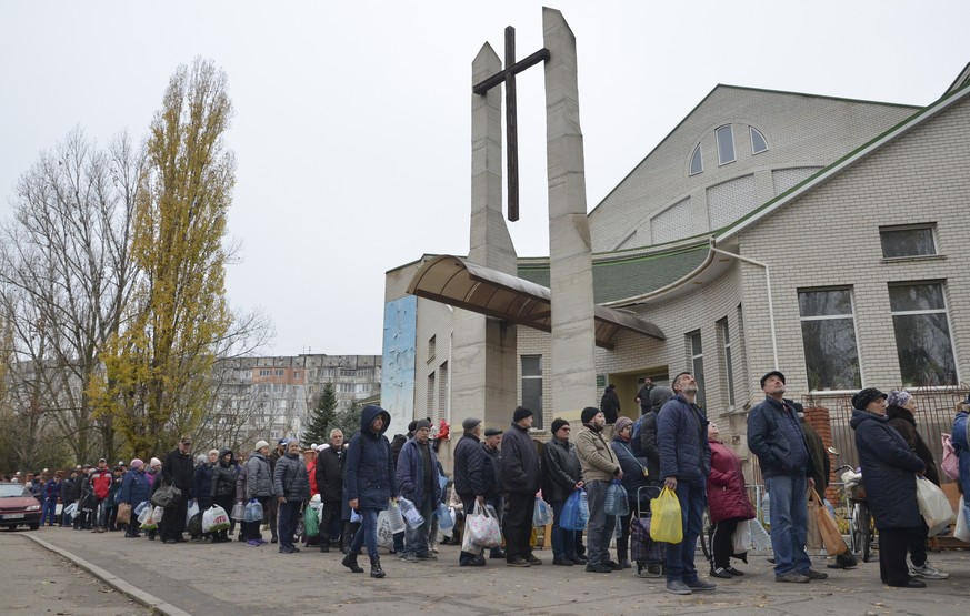 epa10313300 People stand in line to get water in the city of Kherson, Ukraine, 18 November 2022. Ukrainian troops entered Kherson on 11 November after Russian troops had withdrawn from the city. Khers ...