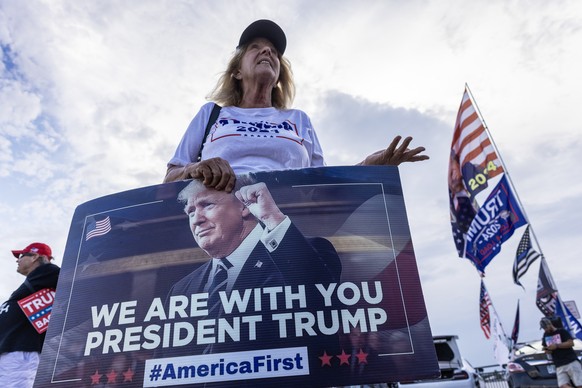 epa11380799 A former US President Donald Trump supporter stands in front of Trump?s Mar-a-Lago property after the guilty verdict in West Palm Beach, Florida, USA, 30 May 2024. Trump was found guilty o ...