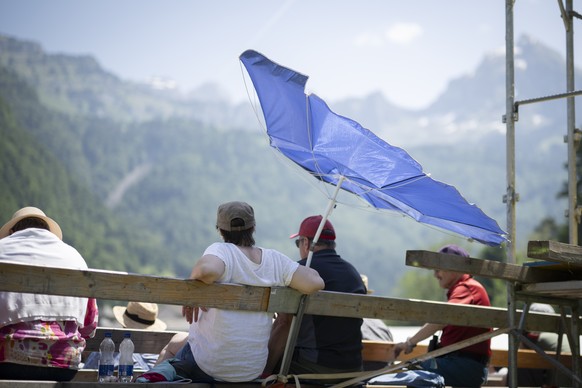 Zuschauer unter einem Sonnenschirm im fuenften Gang beim Glarner Buendner Schwingfest, am Pfingstmontag, 25. Mai 2026, in Naefels. (KEYSTONE/Gian Ehrenzeller)