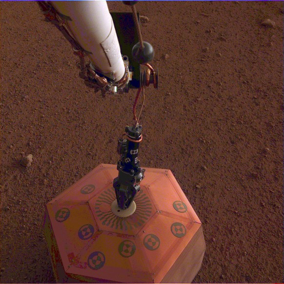 This photo provided by NASA Jet Propulsion Laboratory, shows the new Mars lander placing a quake monitor on the planet’s dusty red surface. The unprecedented milestone occurred less than a month after ...