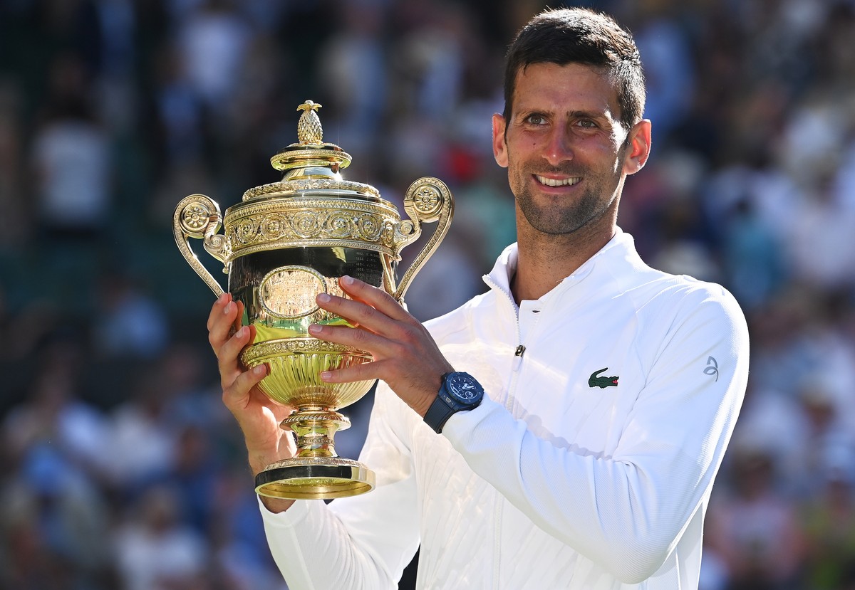 epa10064041 Novak Djokovic of Serbia poses with the trophy after winning the men's final match against Nick Kyrgios of Australia at the Wimbledon Championships, in Wimbledon, Britain, 10 July 202 ...