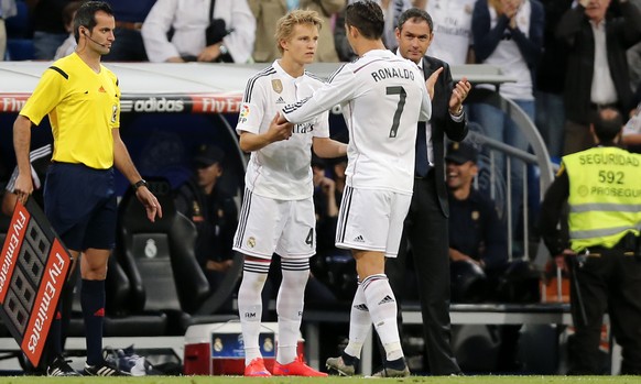 Real Madrid's Cristiano Ronaldo embraces Real Madrid's Martin Odegaard from Norway, center left, as he leaves the field during a Spanish La Liga soccer match between Real Madrid and Getafe at the Sant ...