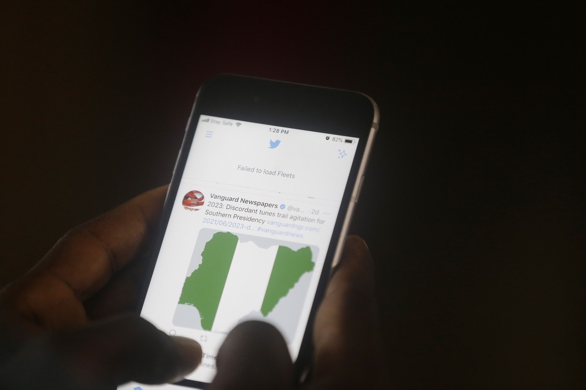 A man used his mobile phone to read headline news on Twitter inside an office in Lagos, Nigeria, Monday June 7, 2021. Nigeria's government announced on Friday that it was suspending Twitter indef ...
