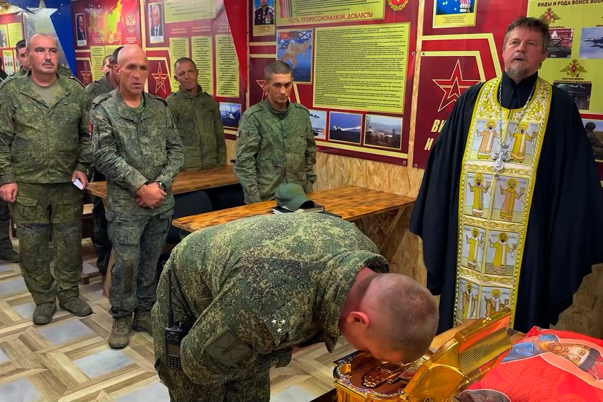 In this image made from video provided by Russian Defense Ministry Press Service, Russian soldiers venerate the relics of Saint Grand Prince Dmitry Donskoy, in an undisclosed location in Ukraine Thurs ...