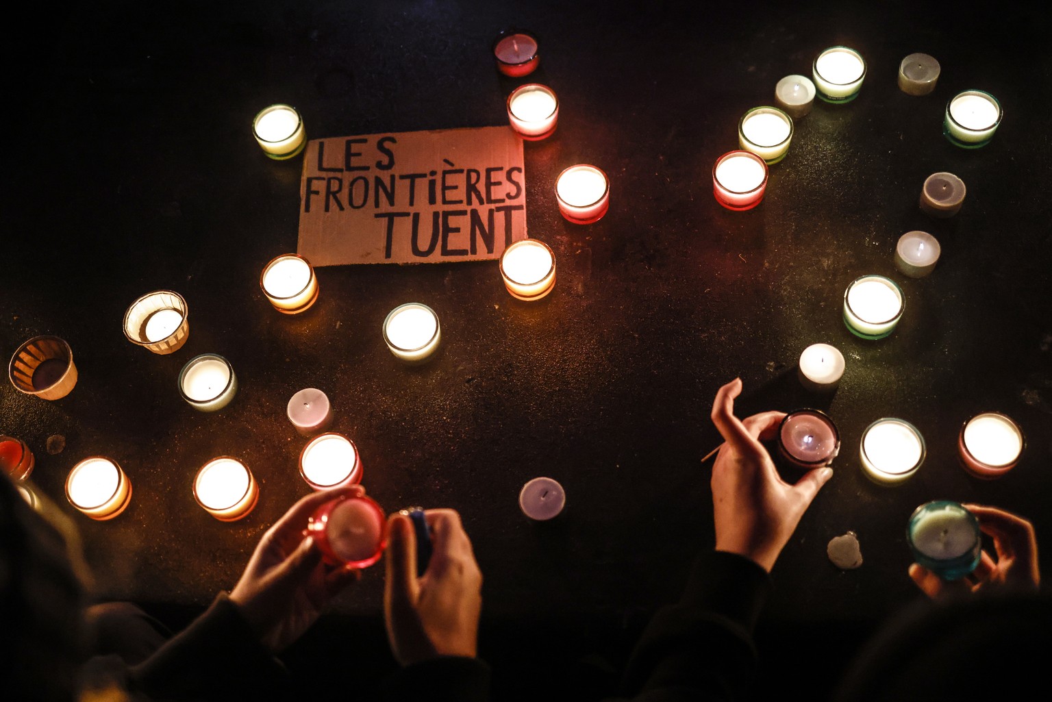 epa09603739 A message ?borders kill? is lighted with candles during a demonstration in support with migrants at Republique square in Paris, France, 25 November 2021. At least 27 migrants have died and ...