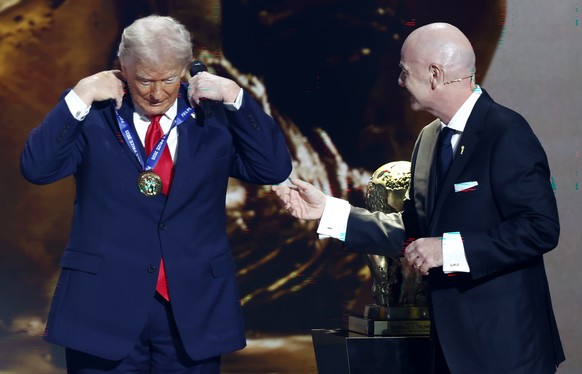 epa12572677 US President Donald Trump (L) receives the FIFA Peace Prize from FIFA President Giovanni Infantino during the FIFA World Cup 2026 Final Draw at the Kennedy Center in Washington DC, USA, 05 ...