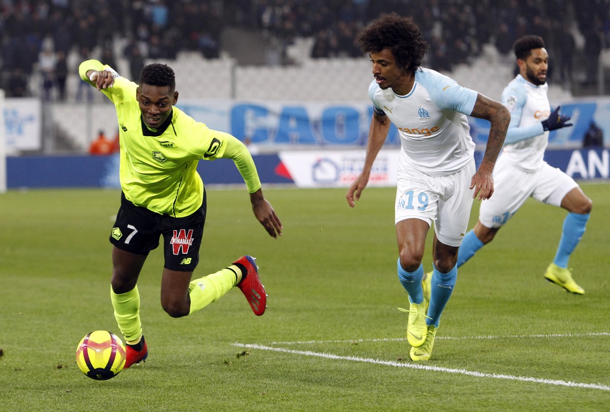 Lille's Rafael Leao, left, battles for the ball with Marseille's Luiz Gustavo during a French League One soccer match between Olympique Marseille and Lille at the Stade Velodrome in Marseill ...
