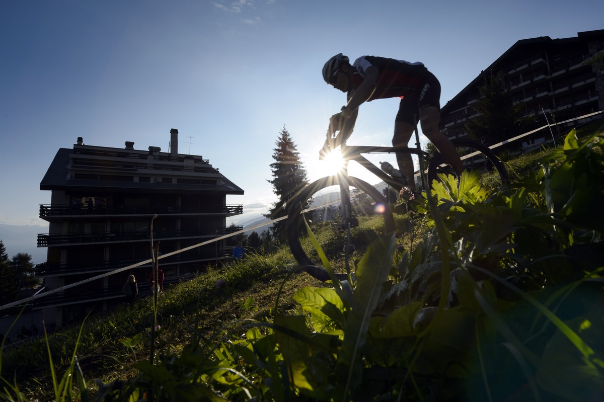 A biker rides down a mountain pasture in Nendaz, during the 25th Swiss Mountain Bike Marathon "Grand Raid" from Verbier to Grimentz, Southwestern Switzerland, Saturday, August 23, 2014. More ...